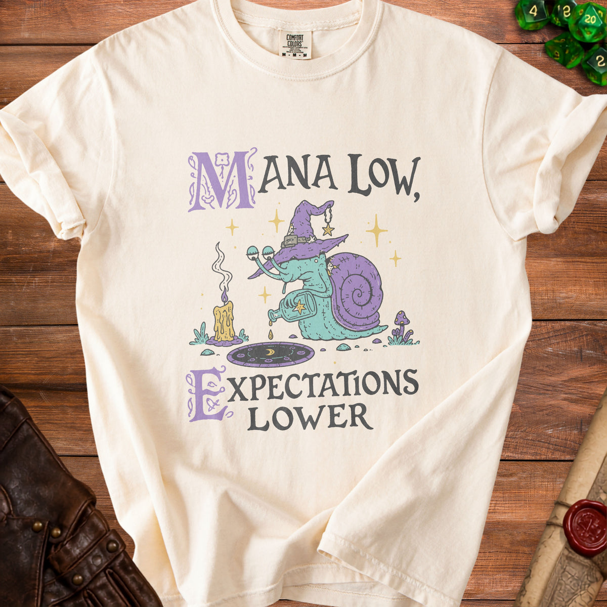 Cream t-shirt with "MANA LOW, EXPECTATIONS LOWER" text and a snail wizard graphic.