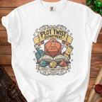 White t-shirt graphic with a d20 die, books, and dice, text reads "Plot Twist Department" and "Expect Complications".