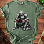 Green t-shirt with a knight in armor sitting next to a bag, reading "I NEED SNACKS".