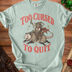 Goblin riding a possum with text "Too Cursed To Quit".