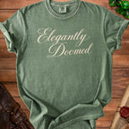 Green t-shirt with "Elegantly Doomed" text and a Comfort Colors tag.