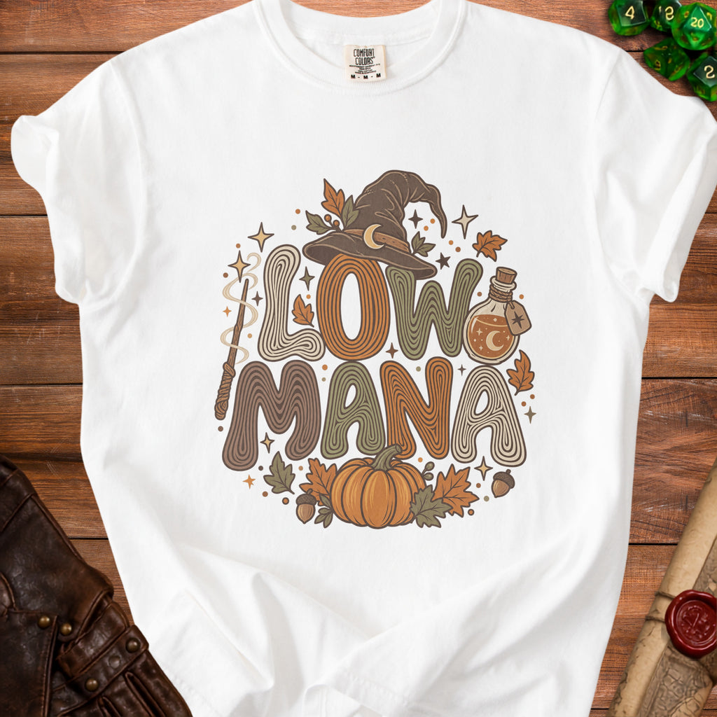 White t-shirt with "Low Mana" text, witch hat, pumpkin, potion, and leaves graphic.
