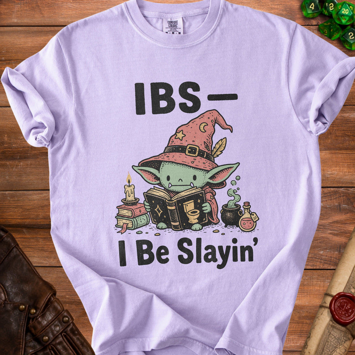 Light purple t-shirt with "IBS- I Be Slayin'" and cartoon wizard reading a book.