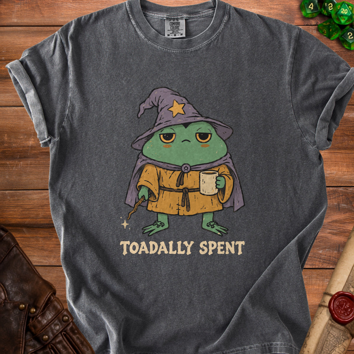Charcoal t-shirt with graphic of tired frog wizard holding coffee and wand. Text says "TOADALLY SPENT".