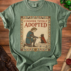 Green t-shirt with medieval knight offering treat to cat, text "Consider Thyself Adopted".