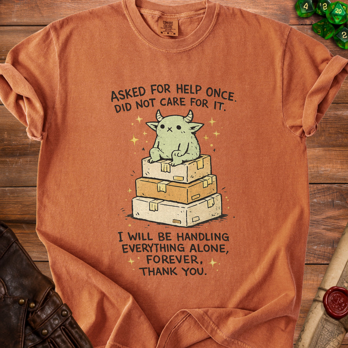 Orange t-shirt with cartoon monster on boxes and text about handling things alone.