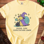 Yellow t-shirt with wizard snail graphic and text "MANA LOW, EXPECTATIONS LOWER".