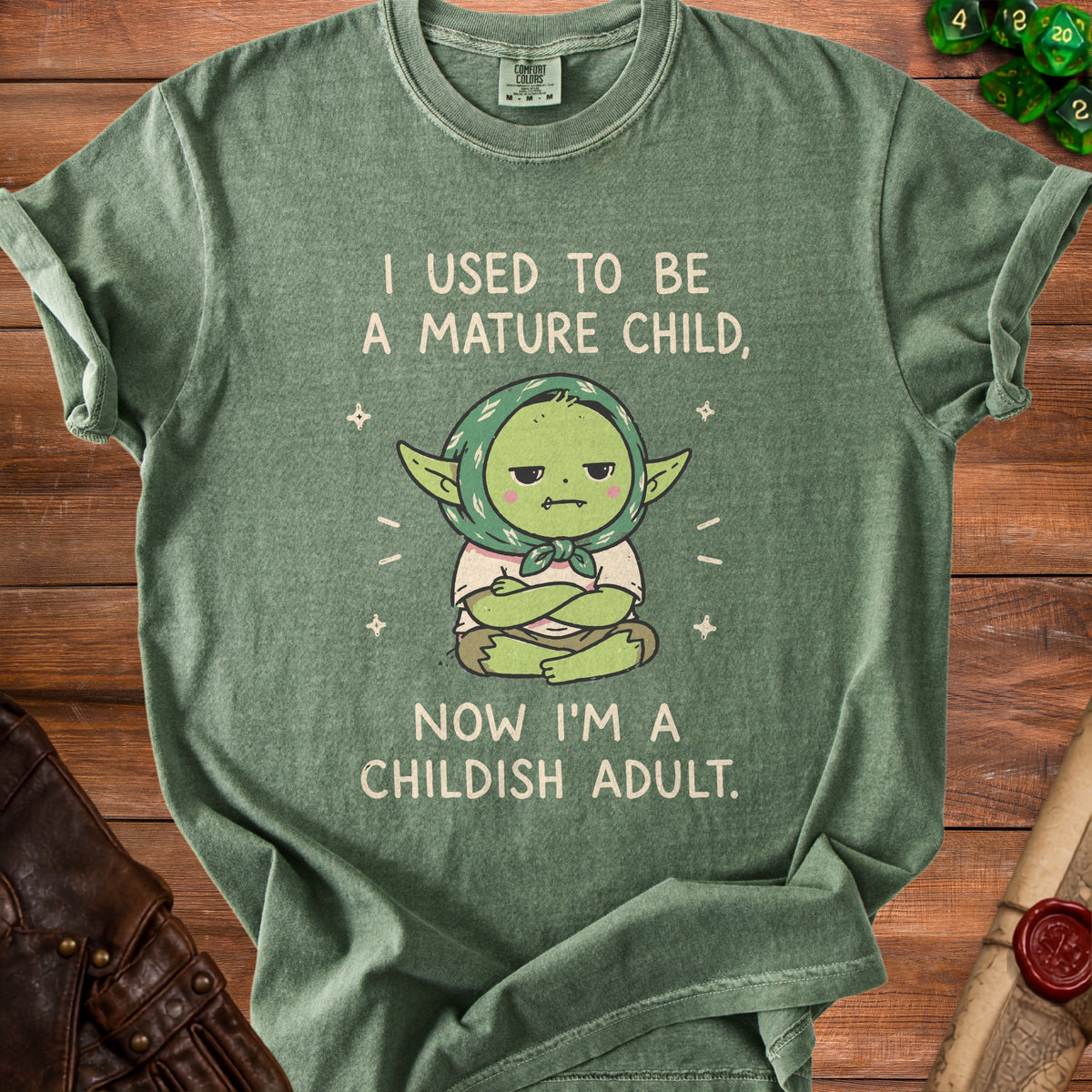 Green t-shirt with cartoon character and text "I used to be a mature child, now I'm a childish adult."
