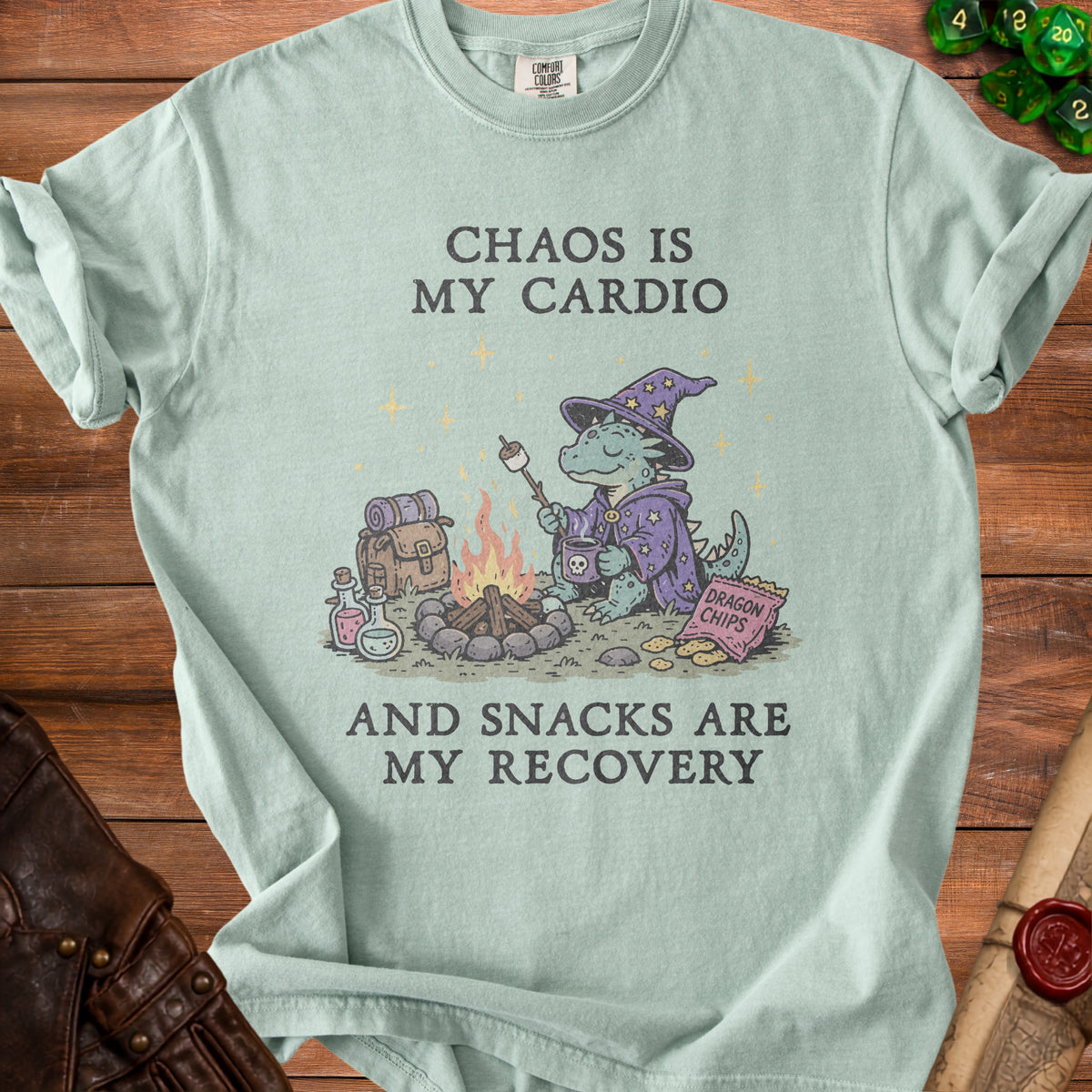 Light blue t-shirt with a wizard dragon toasting a marshmallow and text "Chaos is my cardio and snacks are my recovery."