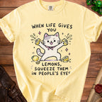 Yellow t-shirt with a cat holding lemons and text "When life gives you lemons, squeeze them in people's eyes".