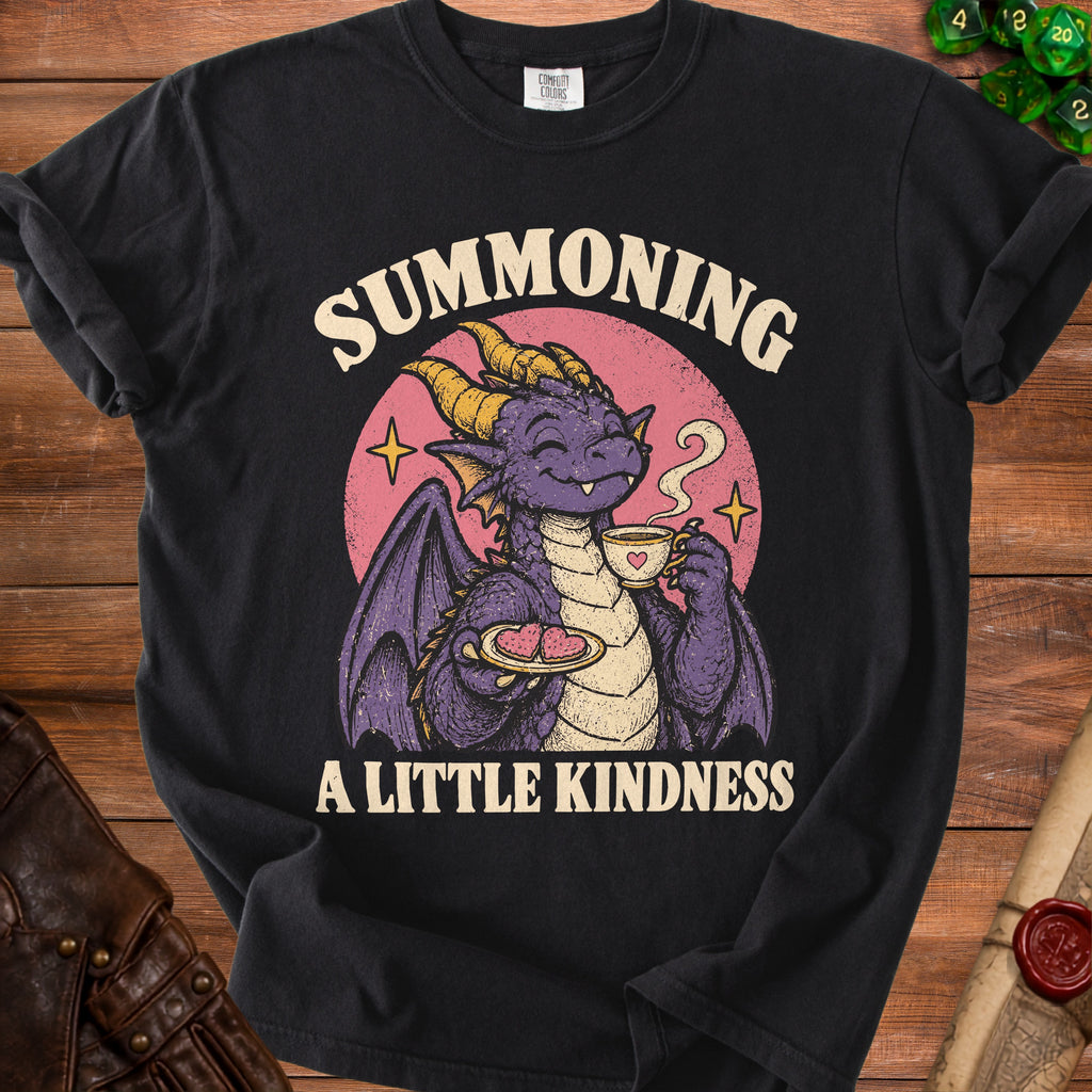 Black t-shirt with purple dragon holding tea and cookies, reads "Summoning A Little Kindness."