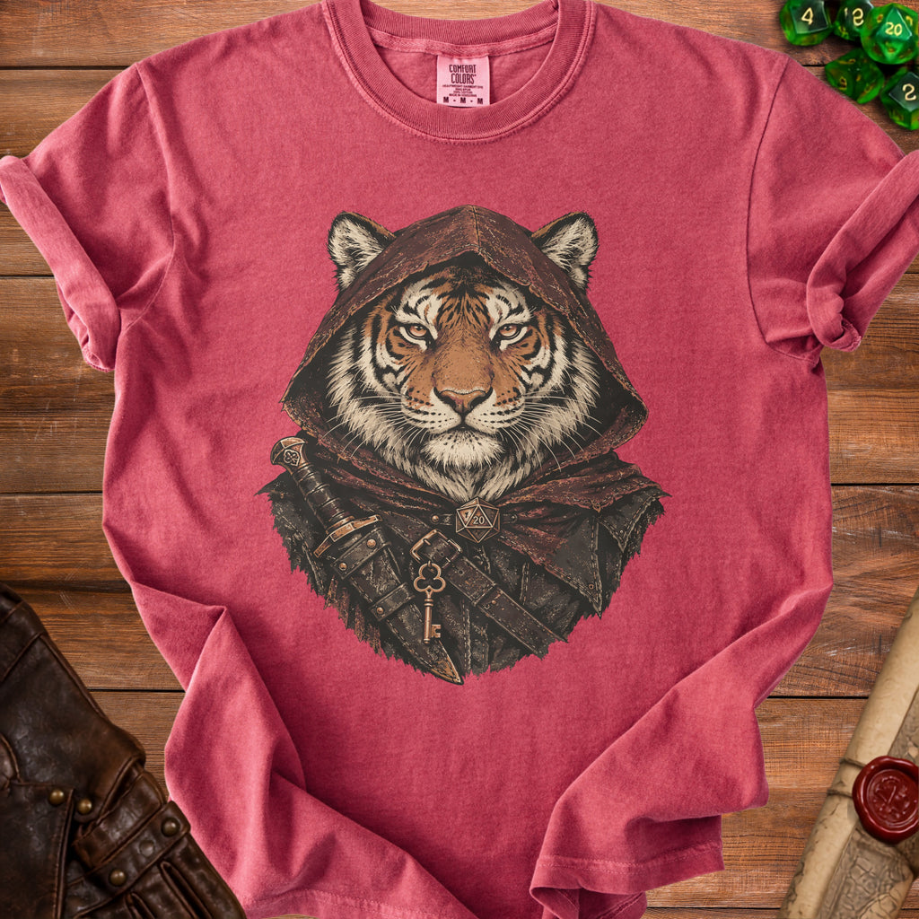 A red t-shirt featuring an illustration of a hooded tiger warrior with a sword and key.