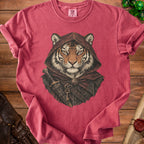 A red t-shirt featuring an illustration of a hooded tiger warrior with a sword and key.