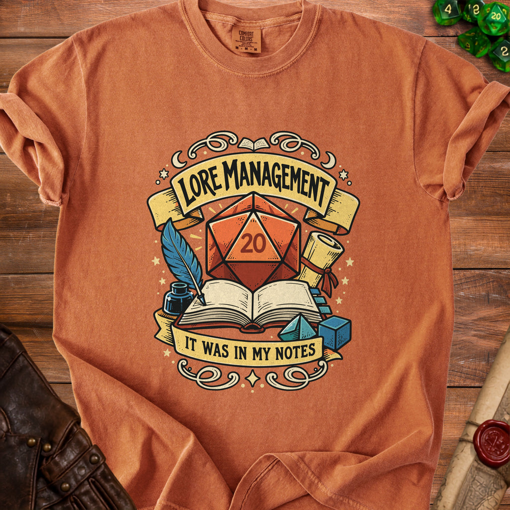 Orange t-shirt with "Lore Management: It Was In My Notes" graphic featuring dice and books.