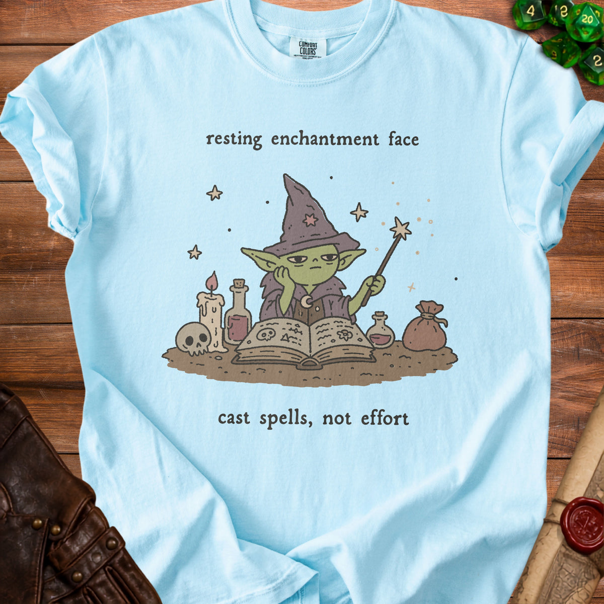 Light blue t-shirt with green wizard graphic and text "resting enchantment face" and "cast spells, not effort".
