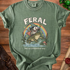 Green t-shirt with opossum wizard riding a frog under a rainbow, text "FERAL but in a whimsical way".