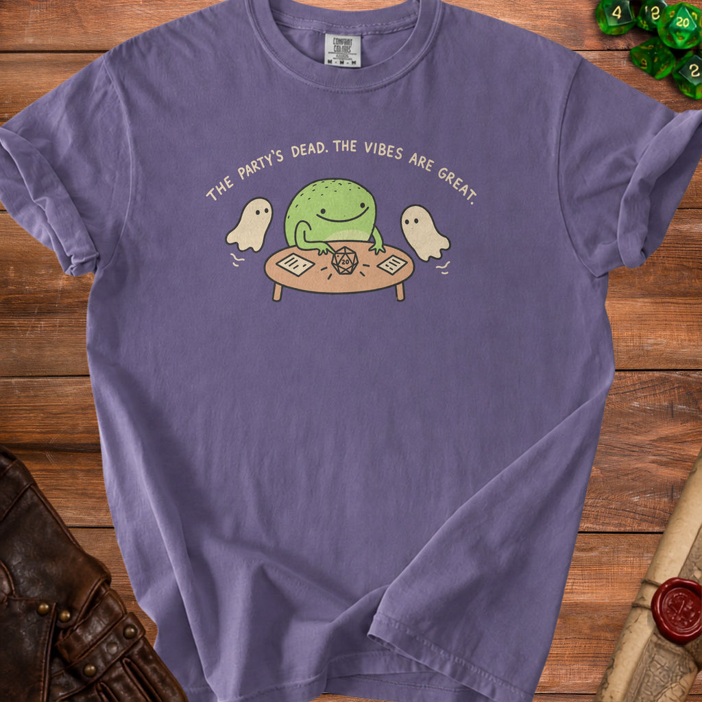 Purple t-shirt with a frog, ghosts, and dice graphic and text.