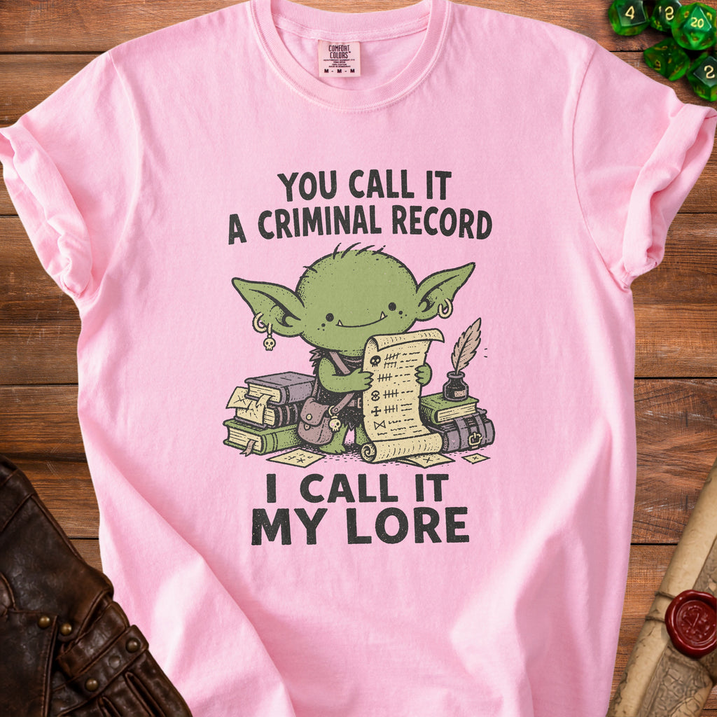 Pink t-shirt with a goblin holding a scroll and books, text reads "You call it a criminal record, I call it my lore."