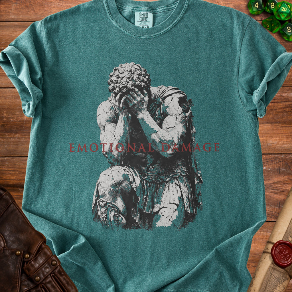Teal t-shirt with a distressed graphic of a kneeling figure and the words "EMOTIONAL DAMAGE".