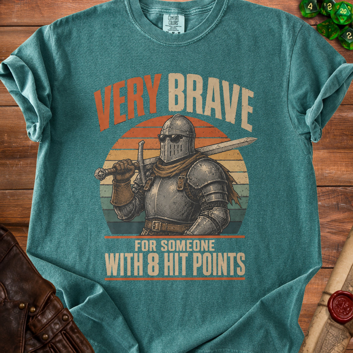 Green t-shirt with a knight wearing sunglasses and holding a sword, text says "VERY BRAVE FOR SOMEONE WITH 8 HIT POINTS".