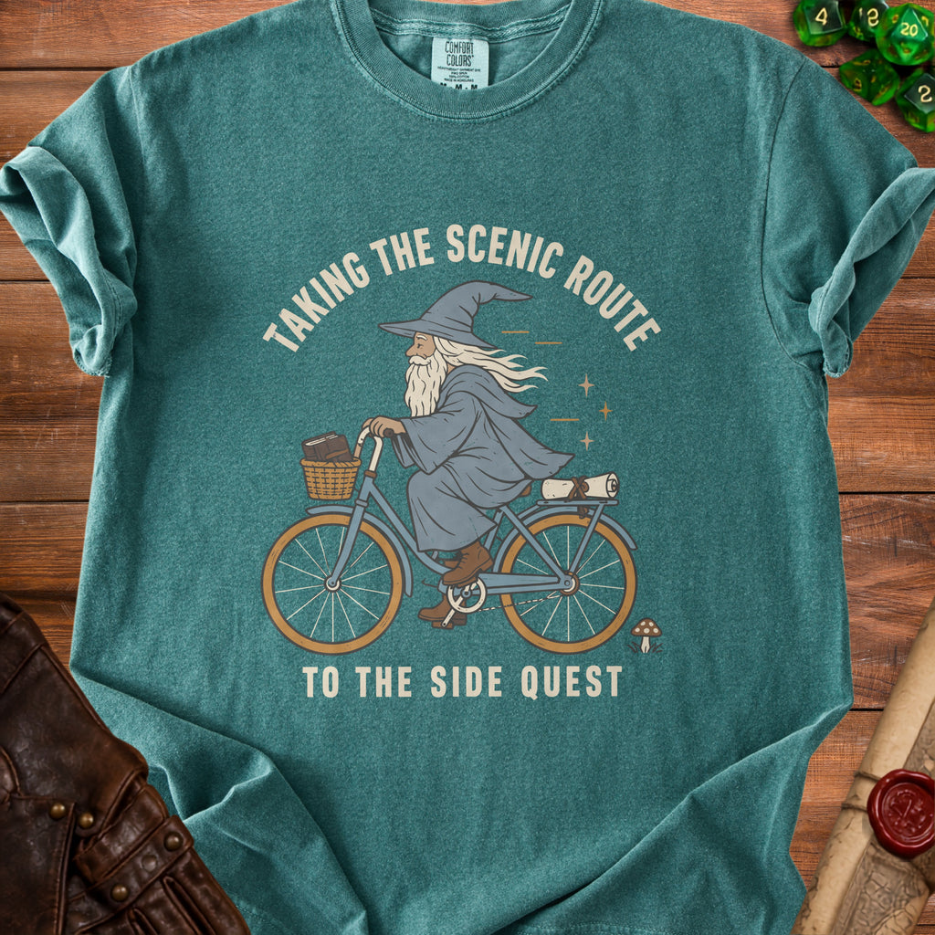 Wizard on a bicycle with basket and scroll, text "Taking the Scenic Route To The Side Quest".