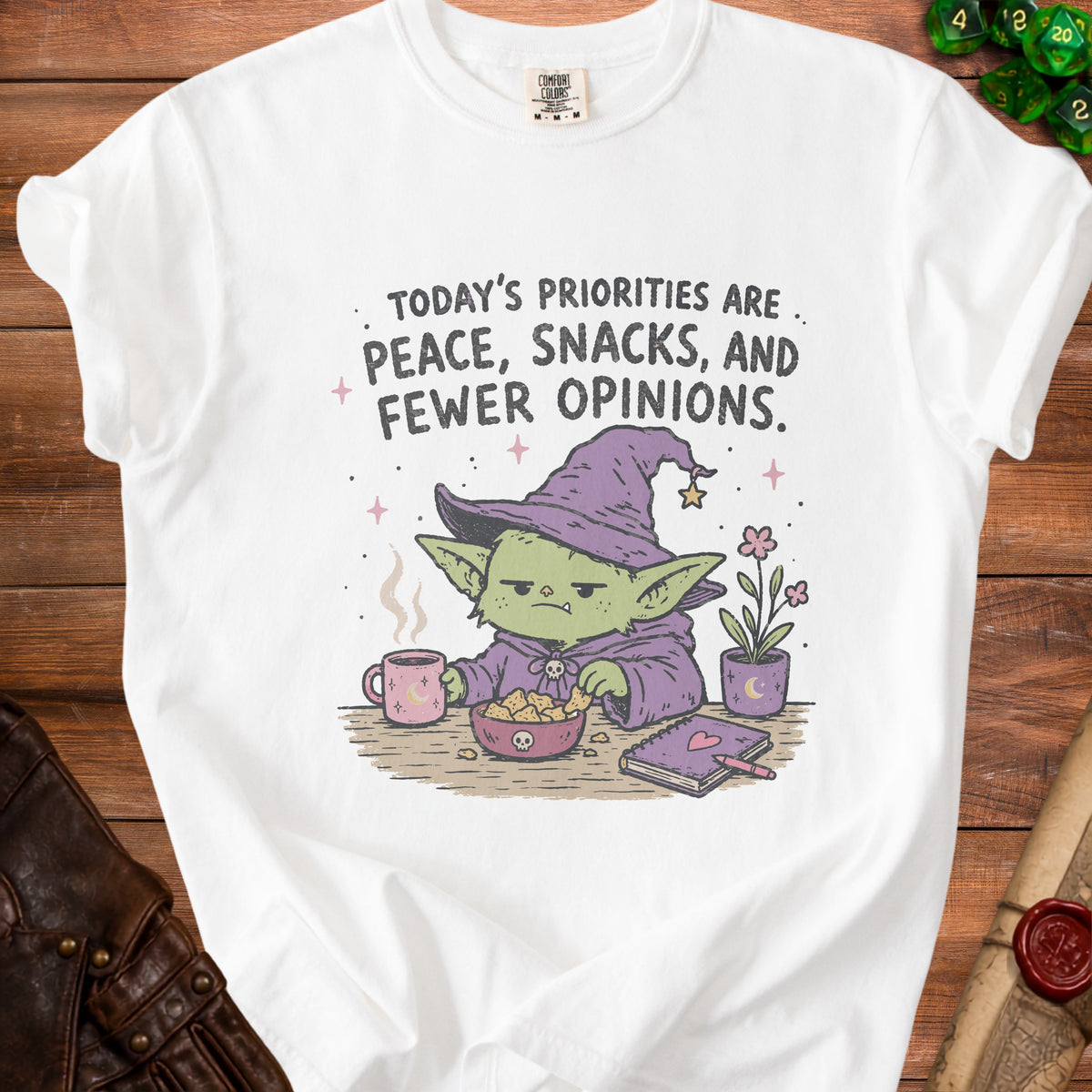 White t-shirt with text: "TODAY'S PRIORITIES ARE PEACE, SNACKS, AND FEWER OPINIONS." and cartoon.