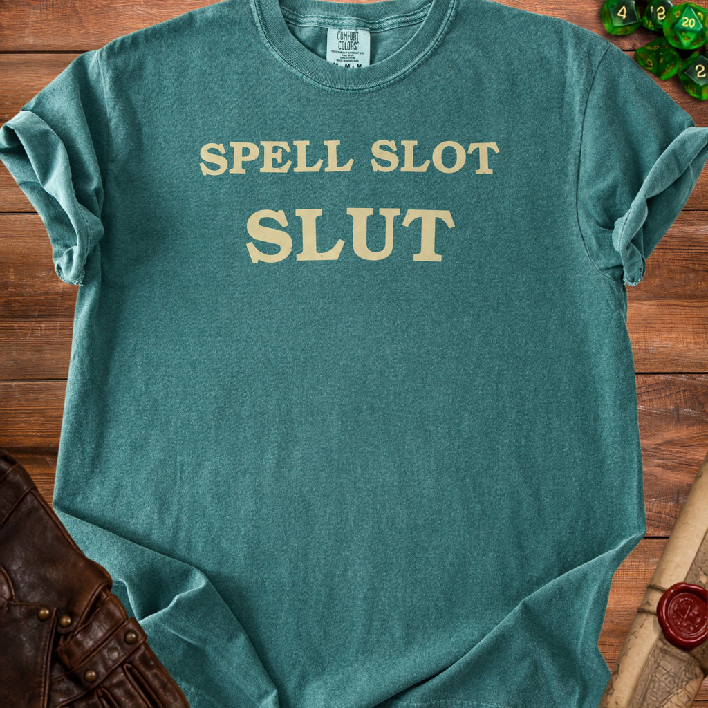 Teal t-shirt with beige text "SPELL SLOT SLUT" and "COMFORT COLORS" label.