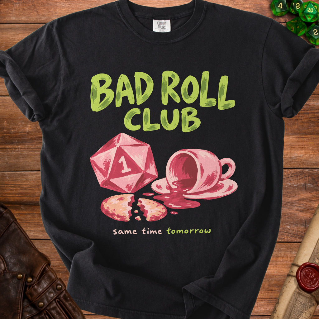 Black t-shirt with "Bad Roll Club" text, a d20 die, and spilled tea.