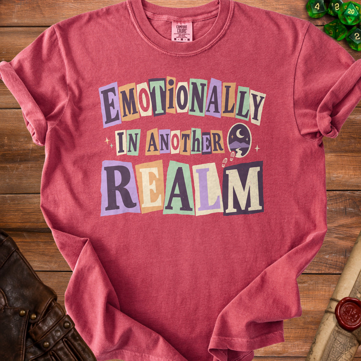Red t-shirt with "Emotionally In Another Realm" text and celestial graphics.