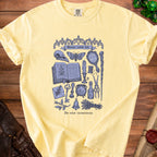 Yellow t-shirt with purple "Minor curse kit" graphic and occult items.