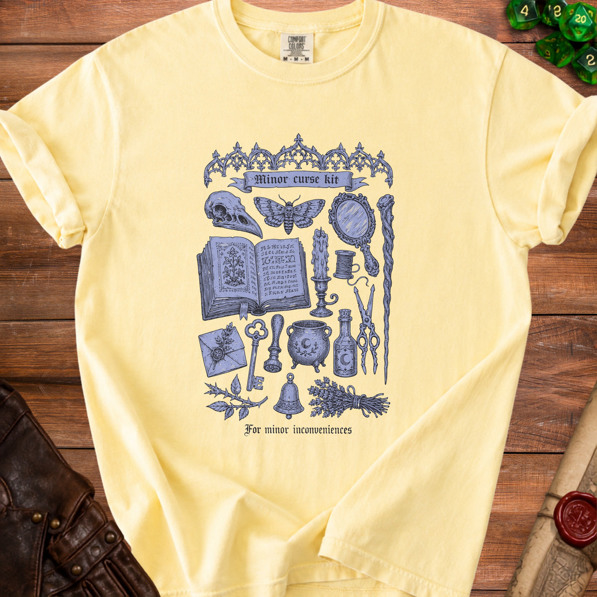 Yellow t-shirt with purple "Minor curse kit" graphic and occult items.