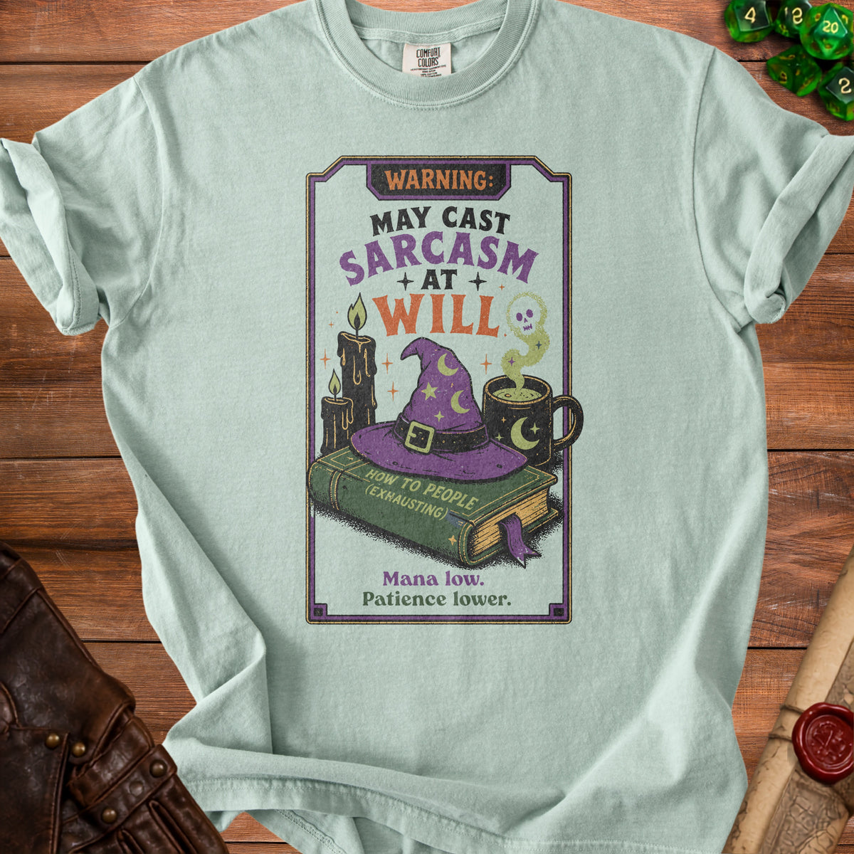 Light teal t-shirt with a graphic reading "Warning: May Cast Sarcasm At Will."