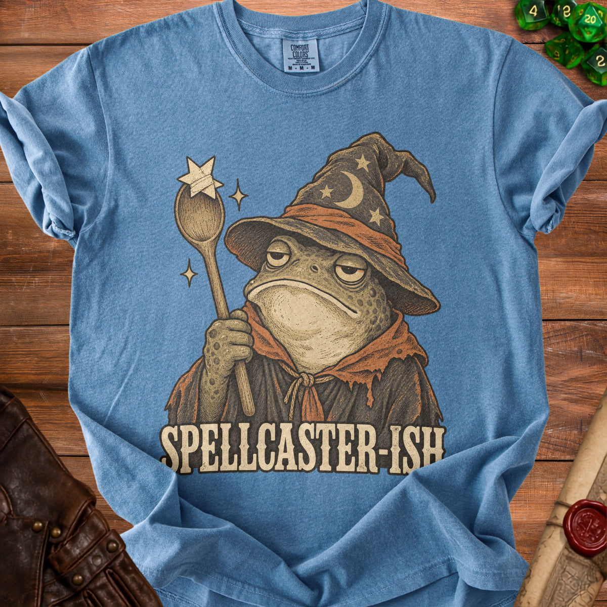 Blue t-shirt with illustration of a bored toad wizard holding a wand, text "SPELLCASTER-ISH".