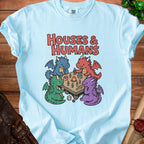 Four dragons play a tabletop game with houses and meeples on a wooden table.