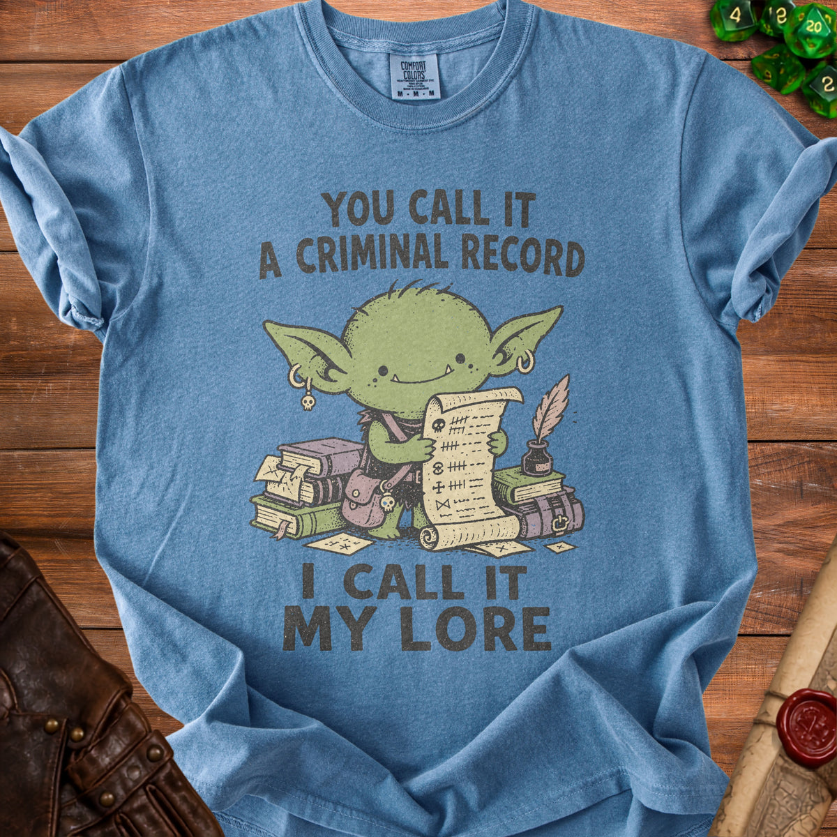 Blue t-shirt with green goblin holding scroll and books, reads "You call it a criminal record, I call it my lore."