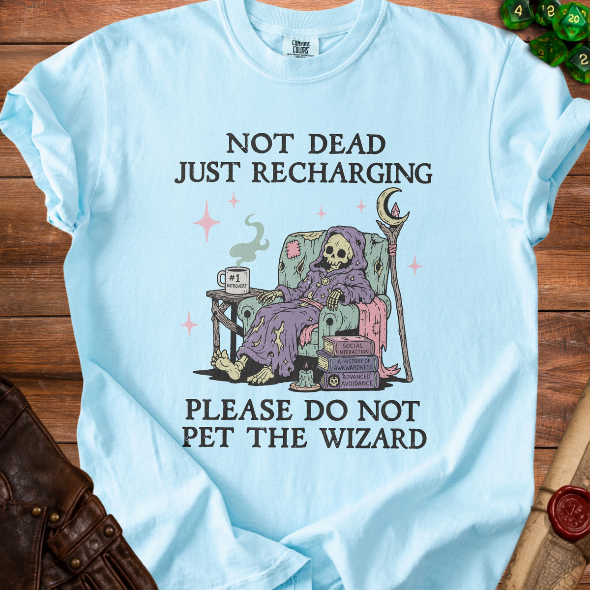Light blue t-shirt with grim reaper in armchair, text "Not Dead Just Recharging," and "Please Do Not Pet the Wizard."
