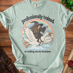 Light green t-shirt with a witch on a goose and text "professionally trained at making worse decisions."