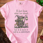 Pink t-shirt with graphic of a goblin explorer and text "I don't know what lies ahead... but I do know it will be an adventure".