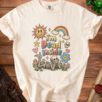 Cream t-shirt with "I'm Dead Inside" graphic featuring skeleton, sun, rainbow, and flowers.