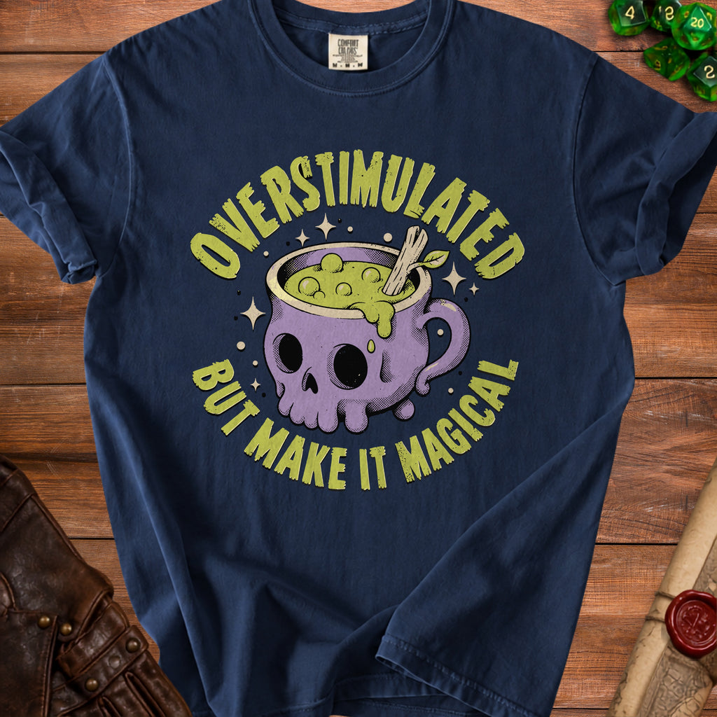 Dark blue t-shirt with a skull cauldron graphic that reads "Overstimulated But Make It Magical."