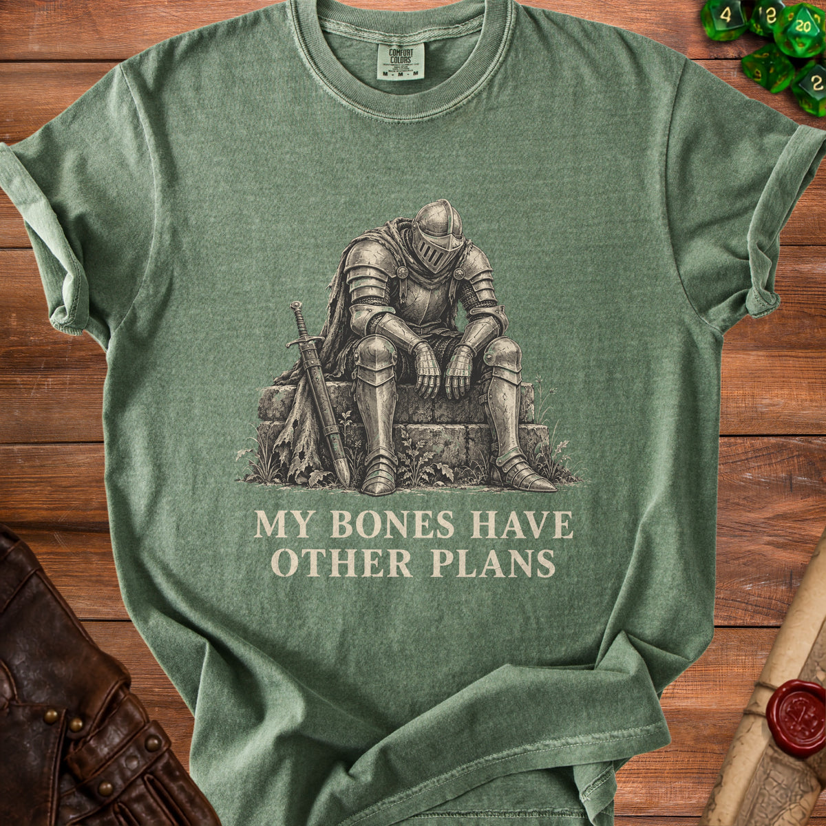 Green t-shirt with a knight sitting next to a sword, text reads "MY BONES HAVE OTHER PLANS".