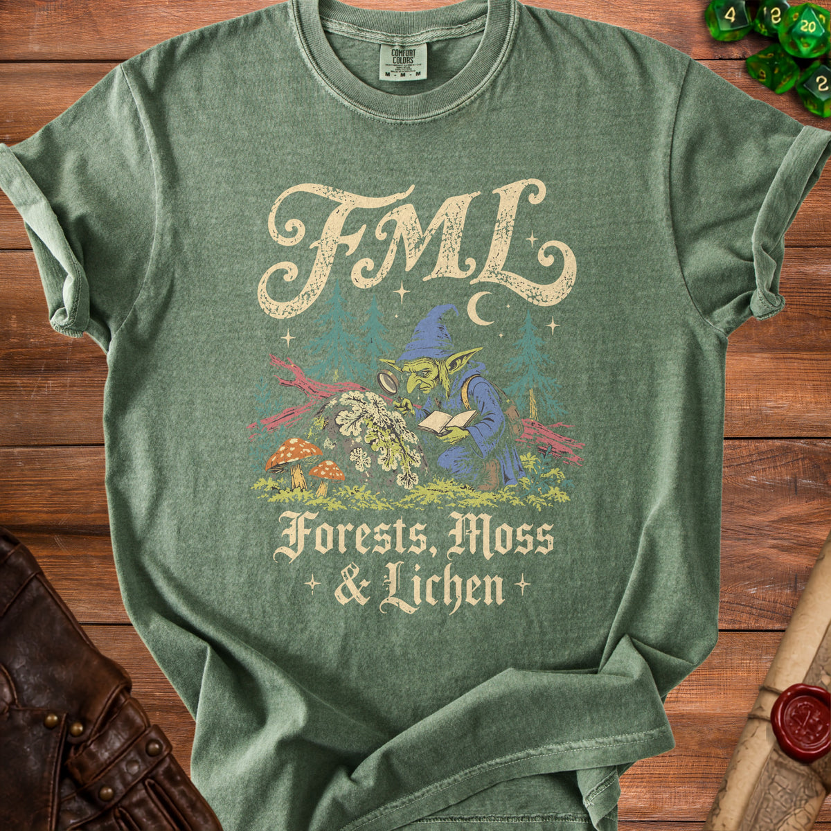Green t-shirt with a goblin examining a book and magnifying glass. "FML Forests, Moss & Lichen" text.