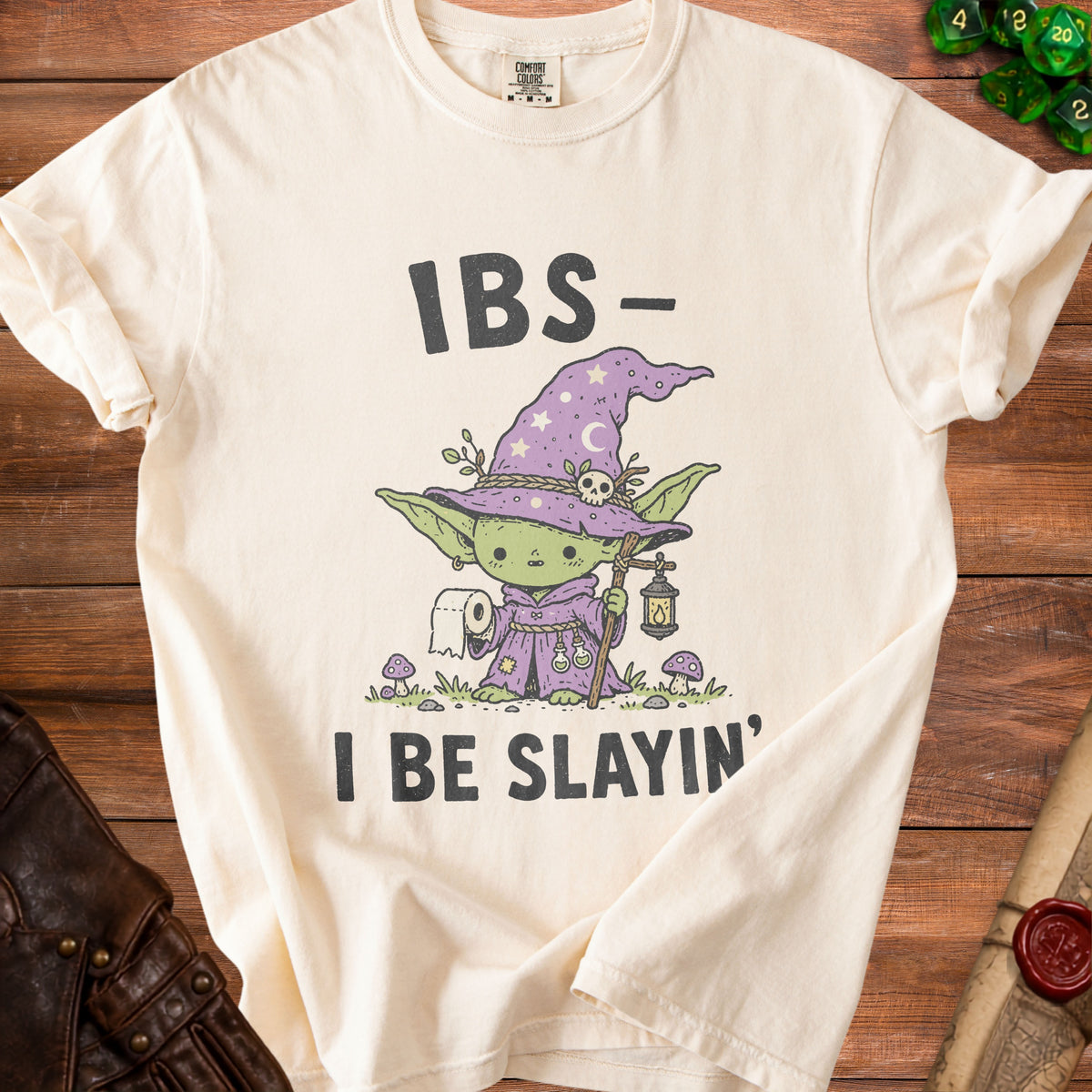 Cream t-shirt with "IBS- I BE SLAYIN'" text and cartoon wizard character.