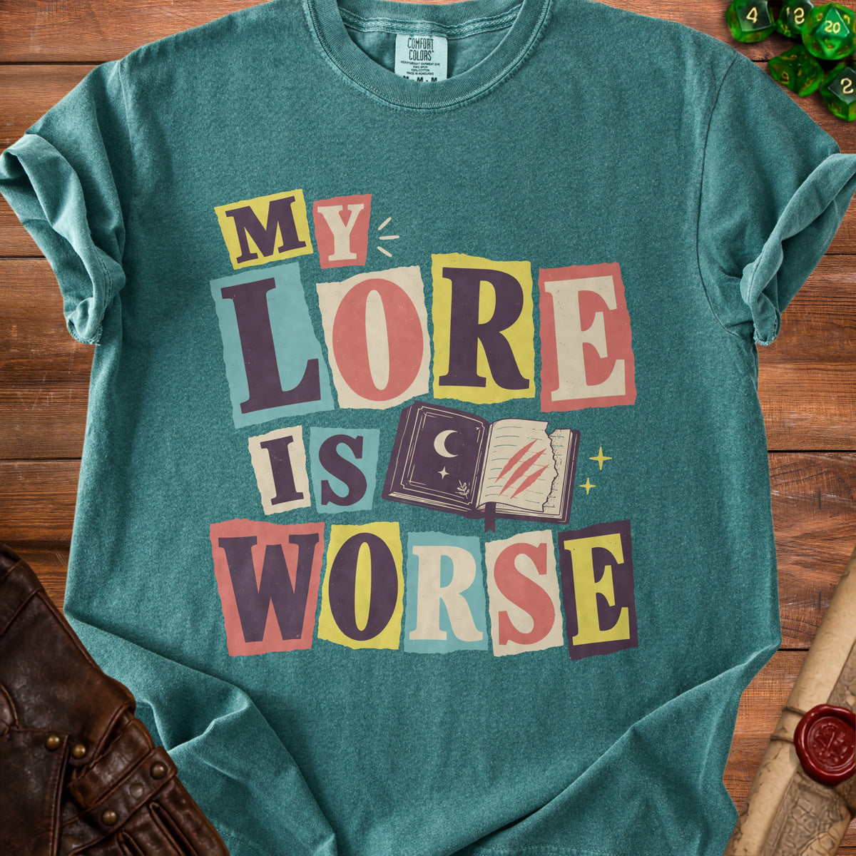 Teal t-shirt with "MY LORE IS WORSE" text and an open book graphic.