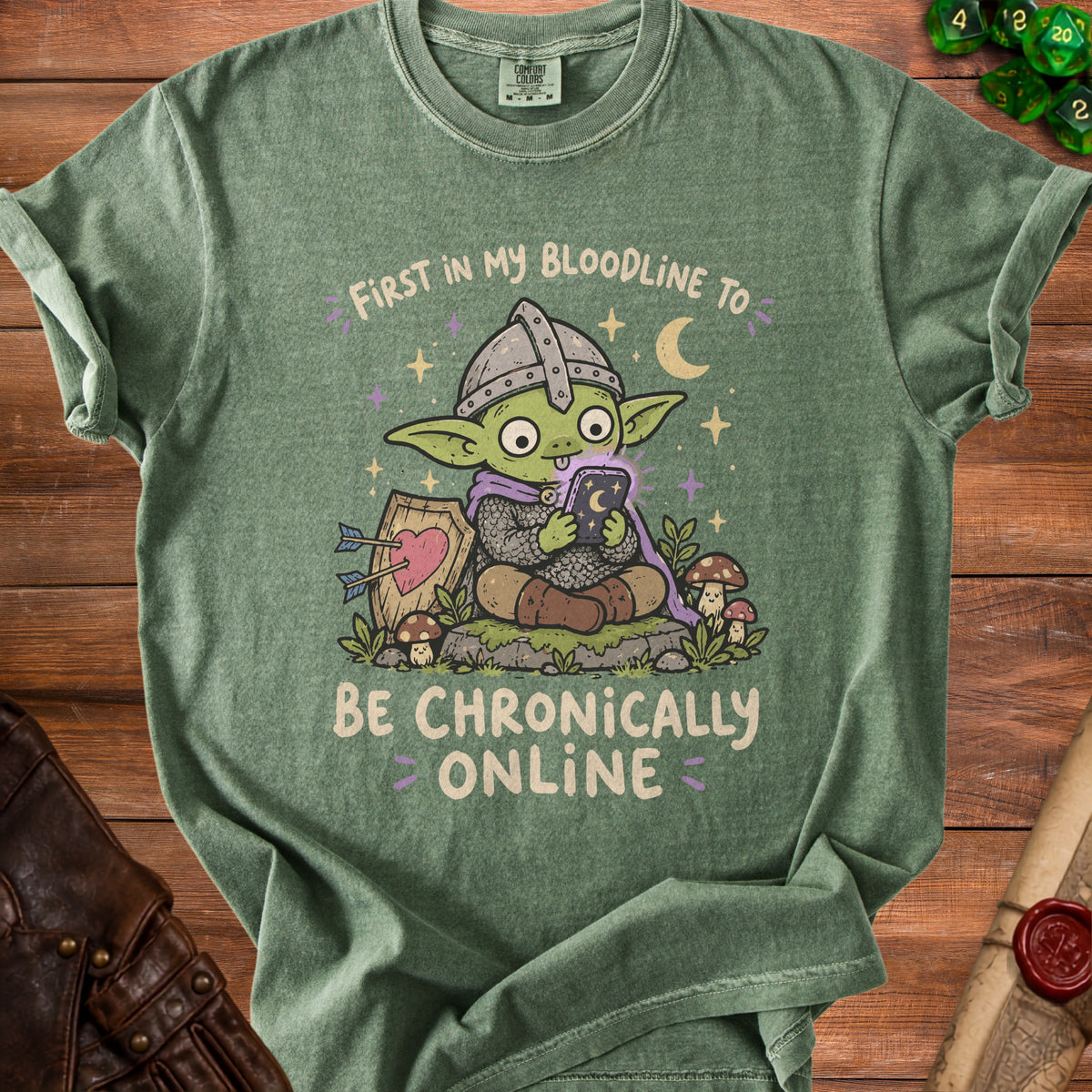 Green t-shirt with illustration of a goblin holding a phone, reading "First in my bloodline to be chronically online."