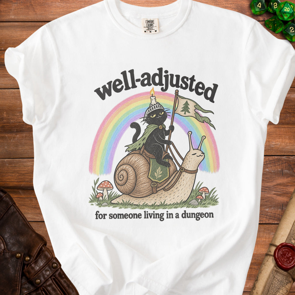White t-shirt with black cat riding snail, text "well-adjusted for someone living in a dungeon".