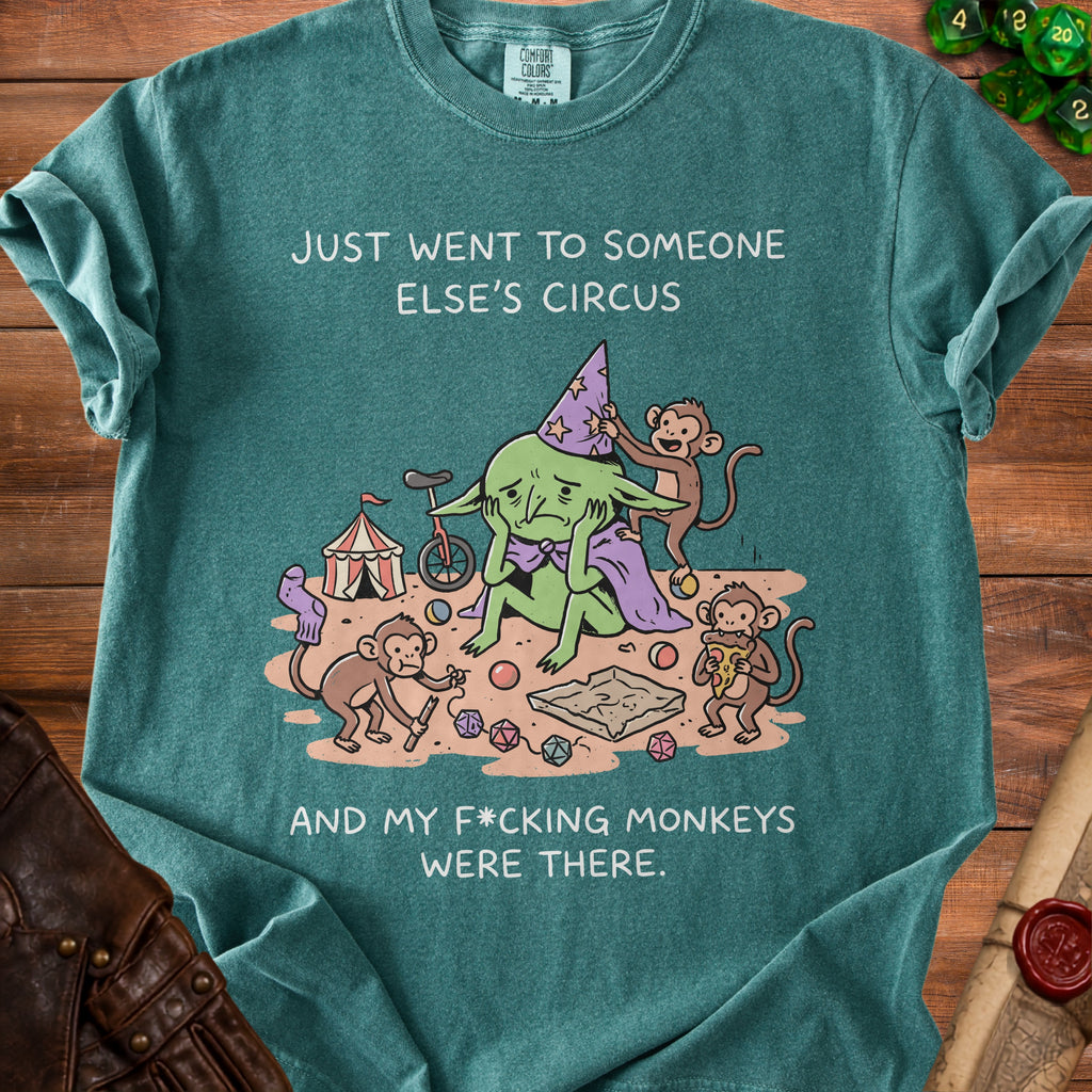 Teal t-shirt with illustration of a sad goblin and monkeys, text "Just went to someone else's circus and my f*cking monkeys were there."