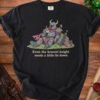 Black t-shirt with illustration of a knight drinking tea and text "Even the bravest knight needs a little lie down."