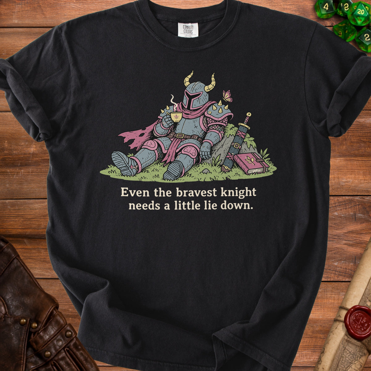 Black t-shirt with illustration of a knight drinking tea and text "Even the bravest knight needs a little lie down."