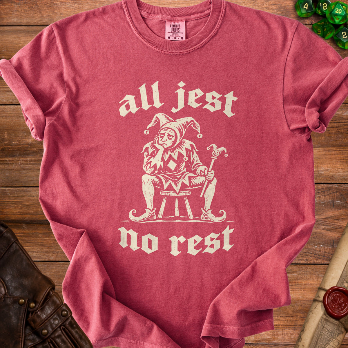 T-shirt with a sad jester graphic and text "all jest no rest."